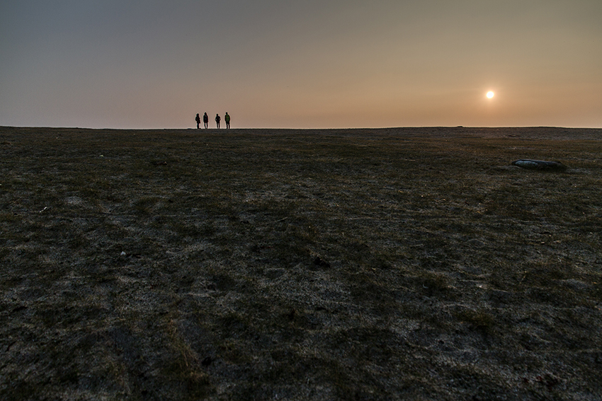 Figures standing on the horizon at sunset
