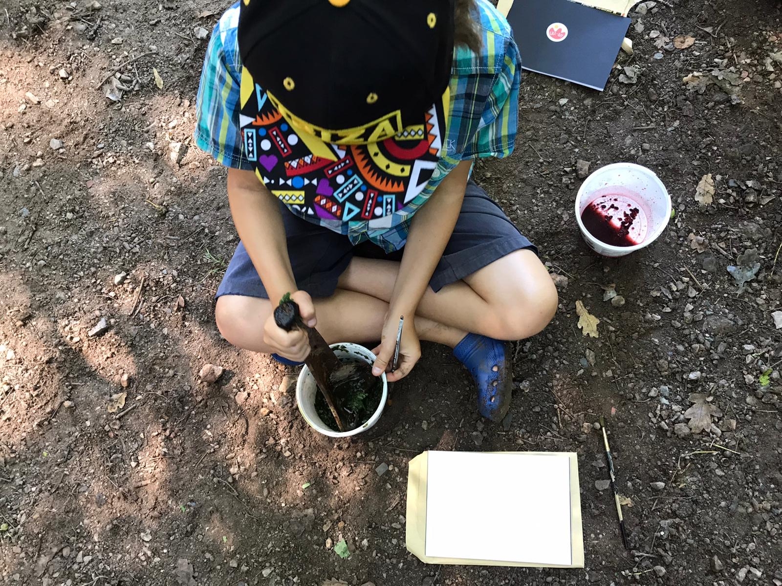 Child mixing natural pigments outside