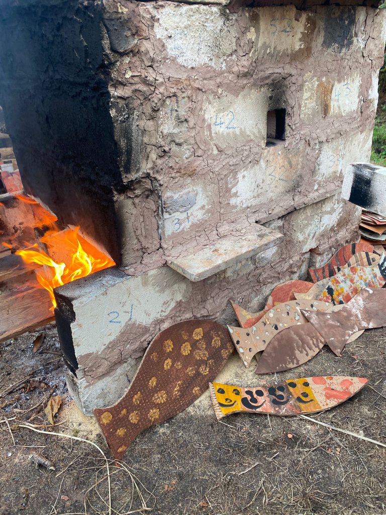 Hand-made wooden fish by a large brick kiln