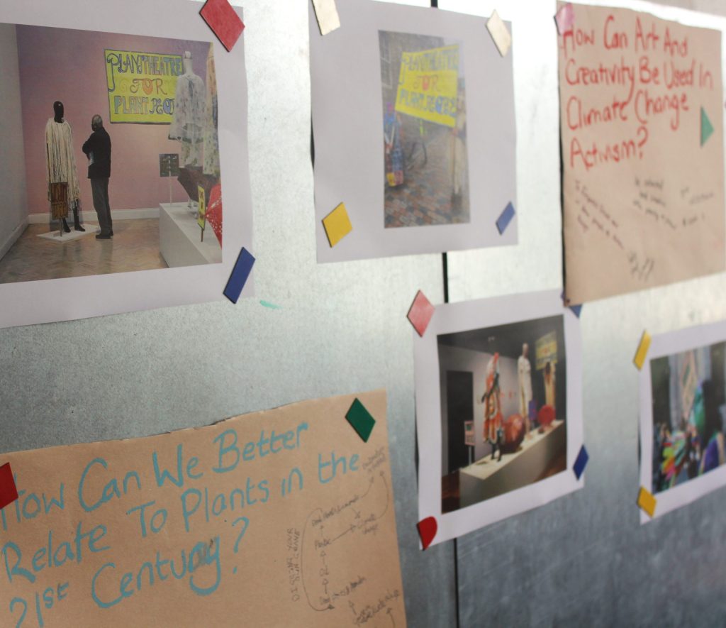 A magnetic board covered in images of Grace Ndiritu's plant-inspired costumes.