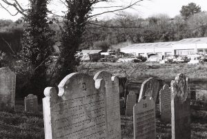 Black and white film image of grave stones including Hebrew engravings. 